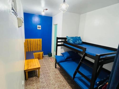 a room with a bunk bed and a blue wall at Mansion Mexicana Private Resort in Calamba