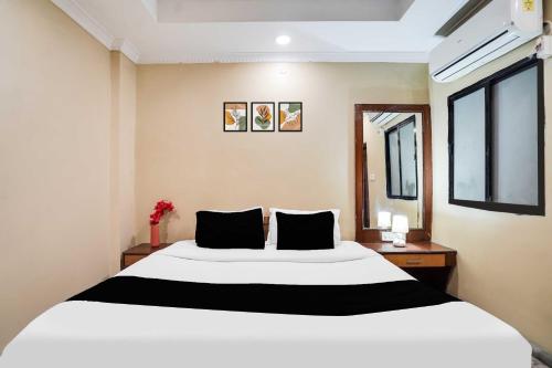 a bedroom with a large white bed with black pillows at Collection O Pithampur in Indore