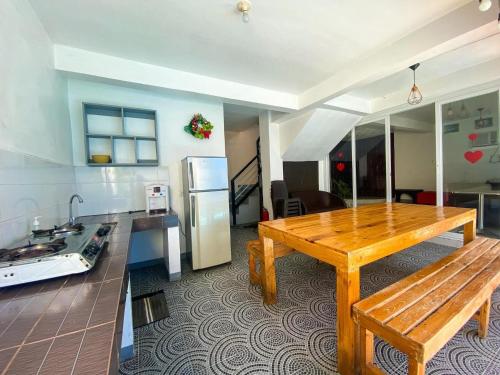 a kitchen with a wooden table and a refrigerator at Mansion Mexicana Private Resort in Calamba