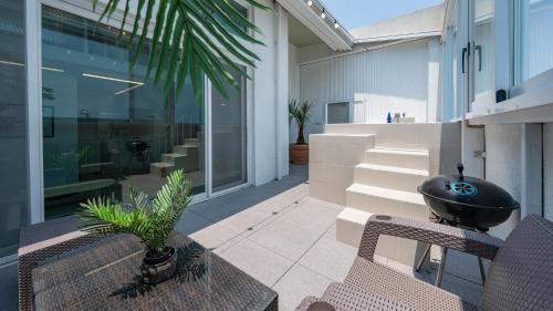 a patio with chairs and a grill on a house at Yeosu Clermonde Pool Villa N Jacuzzi in Yeosu
