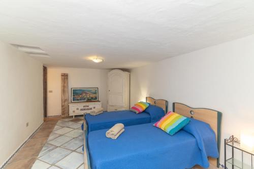 a bedroom with two beds with blue sheets at Villa Ginepro con Piscina Privata in San Teodoro