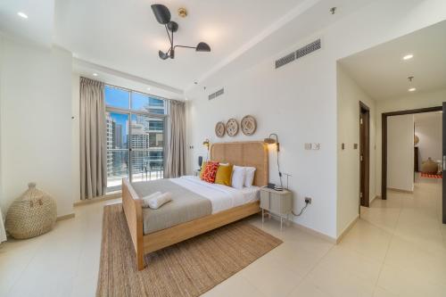 a bedroom with a bed and a large window at Cityscape & Coastal Charm Elegant 2br Seaside in Dubai Marina