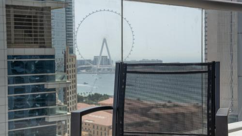 a view of the london eye from a window in a building at Cityscape & Coastal Charm Elegant 2br Seaside in Dubai Marina
