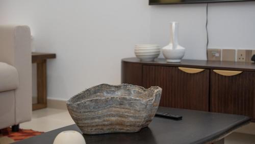 a living room with a table with a stone chair at Cityscape & Coastal Charm Elegant 2br Seaside in Dubai Marina