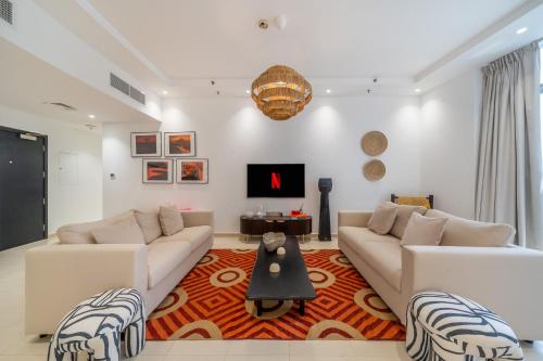 a living room with two couches and a tv at Cityscape & Coastal Charm Elegant 2br Seaside in Dubai Marina