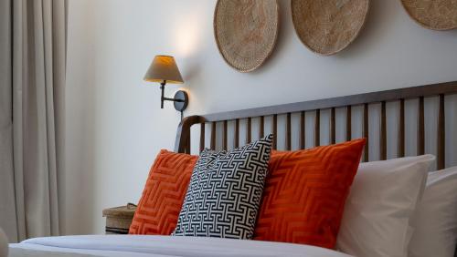 a bedroom with a bed with orange and white pillows at Cityscape & Coastal Charm Elegant 2br Seaside in Dubai Marina