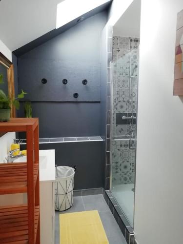 une salle de bain avec une douche avec une porte vitrée dans l'établissement Longère Golfe du Morbihan avec piscine extérieure, à Plescop