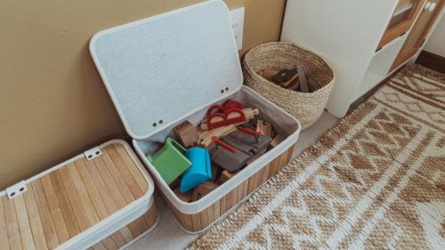 a container filled with toys sitting on the floor at 絶景田園と風を感じる癒しの一棟貸しSawah東浪見 in Ichinomiya