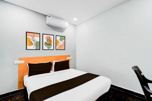 a bedroom with a bed and a white wall at Collection O Malkajgiri in Hyderabad