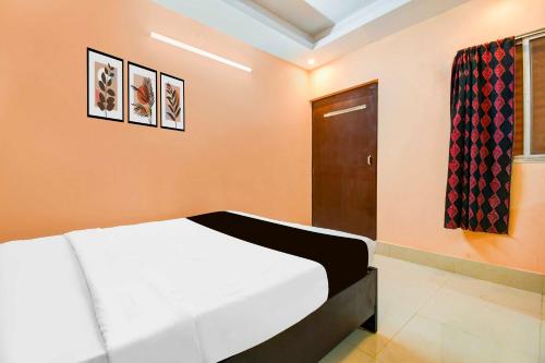a bedroom with a white bed and a door at Collection O Dakshin Dwar in Puri