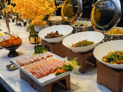 a buffet with bowls of food on a table at Hampton by Hilton Dongguan Fenggang in Dongguan