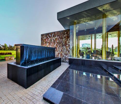 a building with a fountain in front of it at Araiya Gir,A Mavintara Resort in Chitrāwal