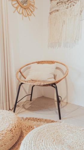a rattan chair with a pillow on it in a room at 絶景田園と風を感じる癒しの一棟貸しSawah東浪見 in Ichinomiya