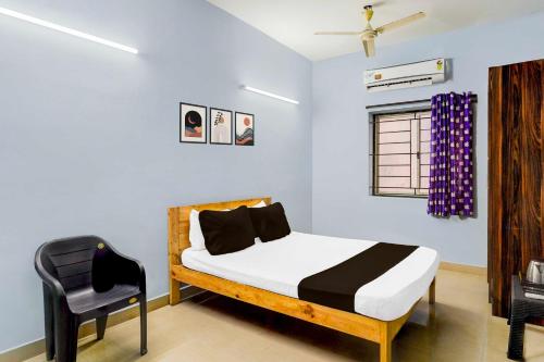 a bedroom with a bed and a chair in it at Collection O Kanathur ECR in Chennai