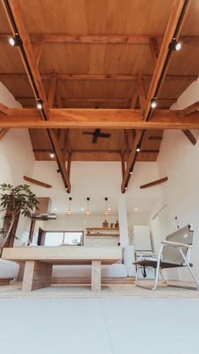 a living room with a table and a chair at 絶景田園と風を感じる癒しの一棟貸しSawah東浪見 in Ichinomiya