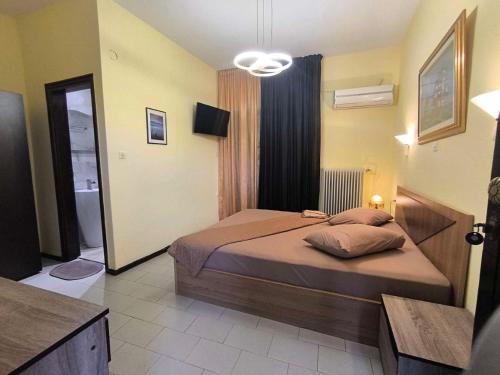 a bedroom with a bed and a bathroom at Hotel Petunia in Neos Marmaras
