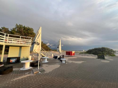 a group of tables and umbrellas on a beach at Ainulaadne Ringmaja liivaranna läheduses in Vääna-Jõesuu