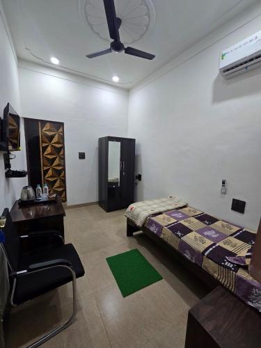a bedroom with a bed and a chair and a ceiling fan at Kaushal Height in Mānpur