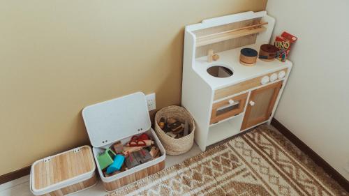 a play kitchen with a toy stove and a cabinet at 絶景田園と風を感じる癒しの一棟貸しSawah東浪見 in Ichinomiya