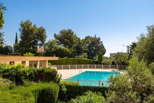 - une piscine dans une cour avec des buissons et des arbres dans l'établissement Happyfew La Suite Nicerama, à Nice