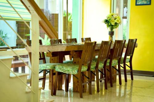 a dining room table with chairs and a vase of flowers at Kenting COMIC B&B&SPRING in Hengchun