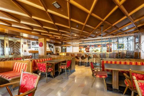a restaurant with wooden ceilings and tables and chairs at keyone rooms Finkenberg in Finkenberg