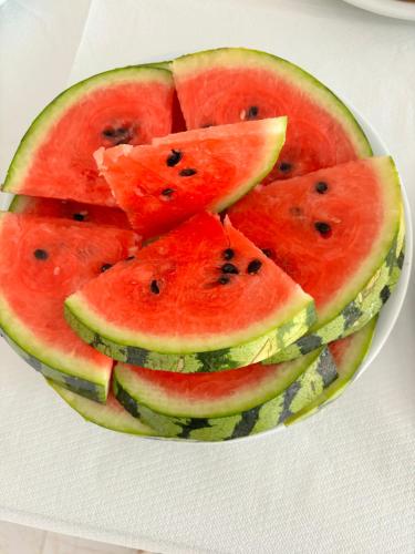 a bowl of watermelon slices on a white plate at Hotel Elite Sarande in Sarandë