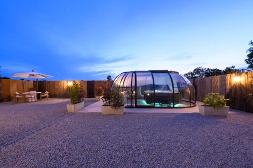 une serre avec des plantes en pot dans une cour arrière dans l'établissement L'Ascalon, à Saint-Sauveur-le-Vicomte