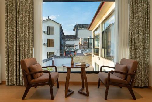 a room with a table and two chairs and a large window at Dali Blue House Sea View B&B in Dali Ancient Town