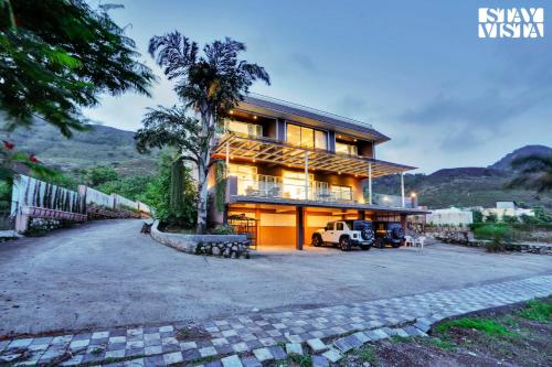 a house with a palm tree in front of it at Villa Veya By VEO - Part Of StayVista in Satara