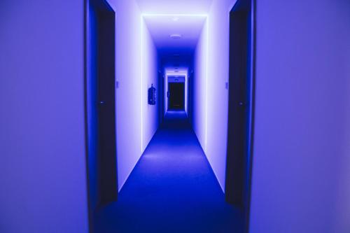 a hallway with a blue light in a building at Penzion Kometa - rodinný pobyt u Novomlýnských jezer s komfortem, restaurací a dětskou zónou in Pasohlávky