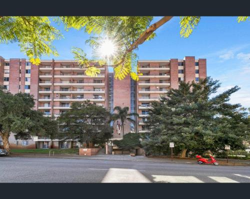 un gran edificio de ladrillo con el sol brillando en él en 1BR Apartment with Free Parking near Perth CBD, en Perth