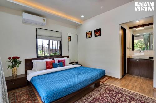 a bedroom with a bed and a bathroom with a sink at Villa Veya By VEO - Part Of StayVista in Satara