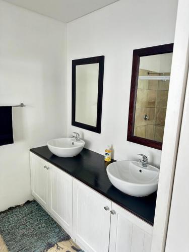 a bathroom with two sinks and a mirror on a counter at Myrtle 3 Bed House in Tokai