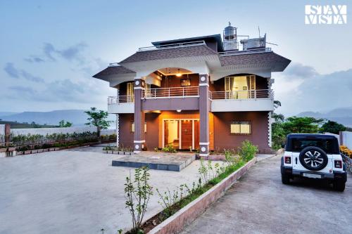 a house with a car parked in front of it at Villa Veya By VEO - Part Of StayVista in Satara