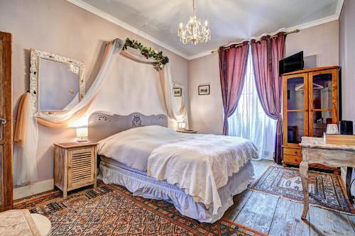 a bedroom with a bed and a chandelier at Château la hussardiere in Vaîte