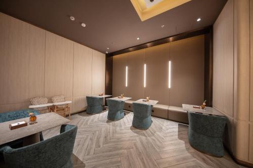 a restaurant with tables and chairs and a large screen at Crystal Hotel Shanghai Lujiazui Oriental Pearl Tower in Shanghai