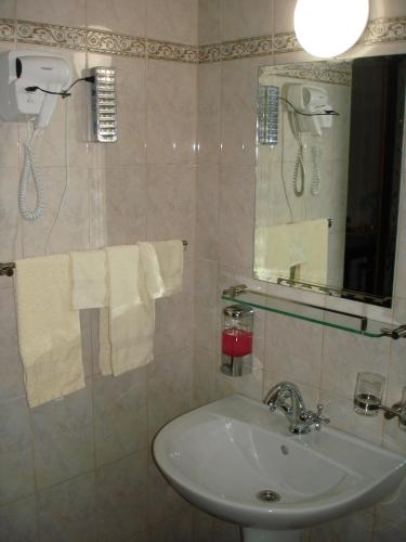 a bathroom with a sink and a mirror and towels at Amir Hotel in Karakol