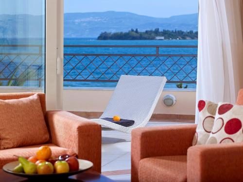 a living room with two chairs and a table with a bowl of fruit at Avantis Suites Hotel in Eretria