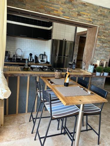 - une cuisine avec une table, des chaises et un comptoir dans l'établissement Aux Angles, appartement cosy, bien equiper, vu sur lac, 5 min a pieds des pites, aux Angles