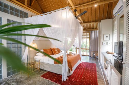 una camera da letto con un letto con zanzariera di Bloomfield Umalas a Canggu