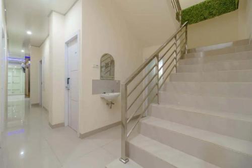 a bathroom with stairs and a sink in a building at RedDoorz Plus near RS RK Charitas 2 Palembang in Palembang