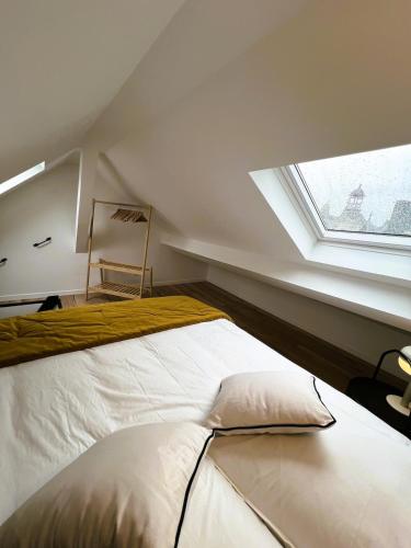 une chambre mansardée avec un lit et une fenêtre dans l'établissement Suite Ma Bohème, 4pers Chic et atypique, à Charleville-Mézières