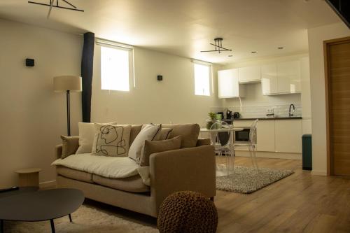 un salon avec un canapé et une cuisine dans l'établissement Suite Ma Bohème, 4pers Chic et atypique, à Charleville-Mézières