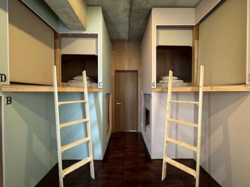a room with two bunk beds and two ladders at 石垣ゲストハウスオハナ in Ishigaki Island