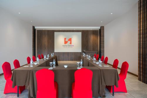 a meeting room with a long table and red chairs at Swiss-Belinn Baloi Batam in Nagoya