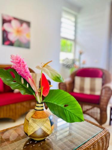 a vase with a flower in it on a table at Villa Ahui Tautira with private lagoon access 