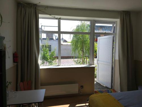 Habitación con ventana grande y puerta. en Herberg Hanenberg, en Wissenkerke