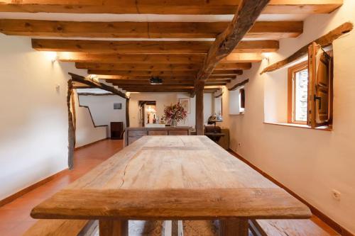 a large wooden table in a room with wooden ceilings at Casa Rural Taller del Nogal 