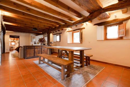 a dining room with a wooden table and benches at Casa Rural Taller del Nogal 